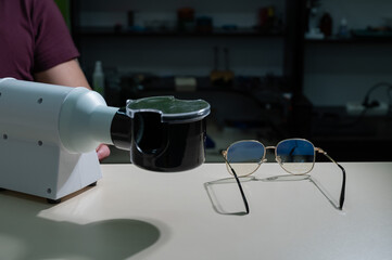 The optician fixes the frames of the glasses.