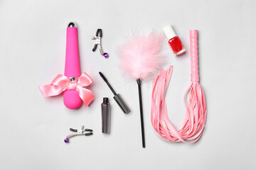 Different sex toys and cosmetics on light background