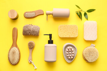 Set of bath supplies with sponges and massage brushes on yellow background
