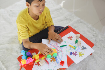 World Autism Awareness day. Boy drawing and playing a toys. Mental health care concept. Psychology,...