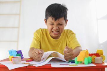Emotional Tantrum and Angry boy while drawing on paper. Childhood traumatic experience, psychology,...