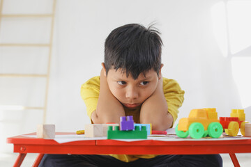 Boy feel bored and sad while playing alone at home. Childhood traumatic experience, psychology,...