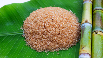 Sugar cane with brown sugar on banana leaf