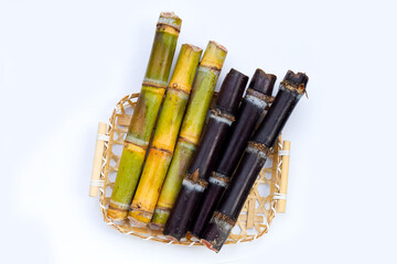 Sugar cane with brown sugar in bamboo basket on white background