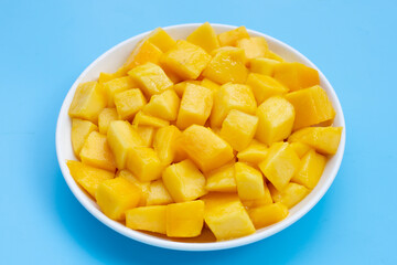 Tropical fruit, Mango cube slices in white bowl on blue background.