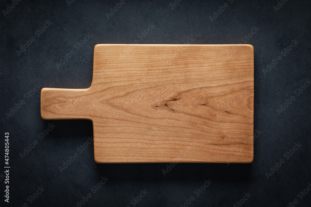 Sticker handmade cherry wood cutting board on the dark tabletop. - Stickers