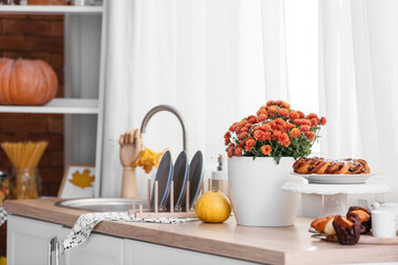 Pot with beautiful Chrysanthemum flowers on table in kitchen