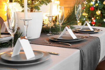Dining table with beautiful setting for Christmas celebration and blank cards indoors