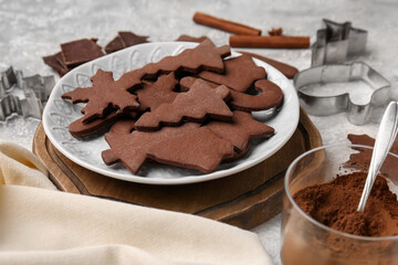 Plate with tasty chocolate Christmas cookies on light background