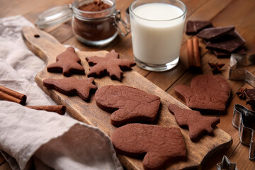 Board with tasty chocolate Christmas cookies on wooden background