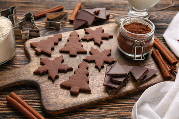 Board with tasty chocolate Christmas cookies on wooden background