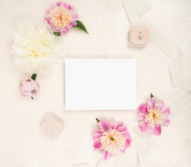 Fresh peony flower flat lay with a blank invitation card, fresh blooms and velvet ring box
