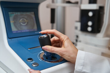 Doctor using joystick of automated refractor during eye diagnostics © Viacheslav Yakobchuk