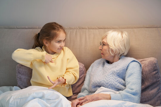 Granddaughter and grandma communicating with help of sign language - Powered by Adobe