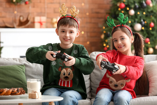 Cute Little Children Playing Video Game At Home On Christmas Eve