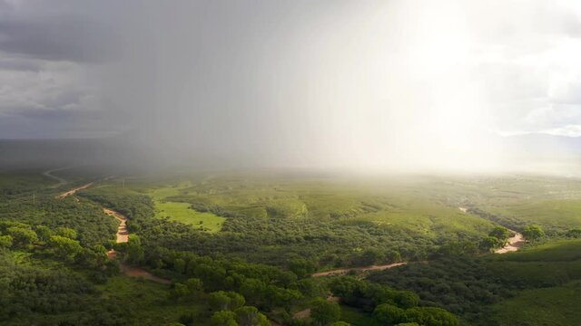 Dramatic monsoon rain storm over grassland in Arizona with river bend.