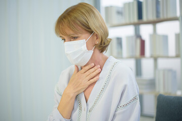 Senior caucasian woman wearing a mask feeling sick