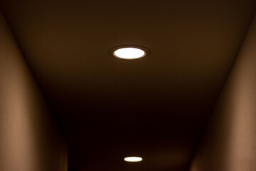 薄暗い通路を照らす天井の小さなライト