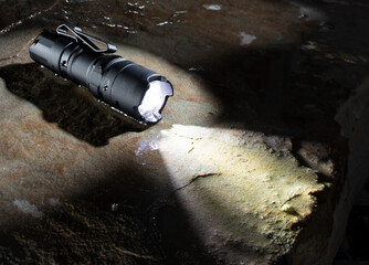 Waterproof flashlight on a wet rock
