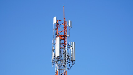 Telecommunication tower of 4G and 5G cellular. Macro Base Station. 5G radio network telecommunication equipment with radio modules and smart antennas mounted on a metal against blue sky background.