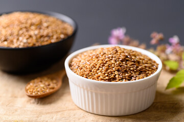 Close up of golden flax seed in bowl on wooden background