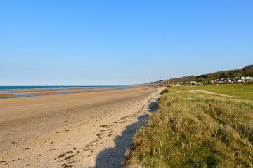 The beach of Omaha beach at the edge of the English Channel in Europe, in France, in Normandy, towards Arromanches, in Colleville, in spring, on a sunny day.