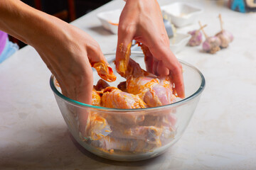 chicken drumsticks in a cup are mixed with seasonings