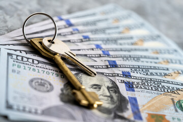 Set of house keys on 100 dollar bills texture.