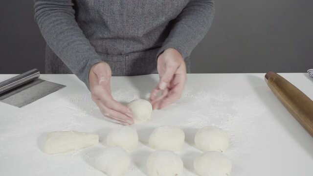 Rolling bread dough with a french rolling pin to make homemade flatbread.