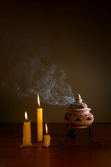 incense burning in an incense burner on the table with candles.Religion concept.