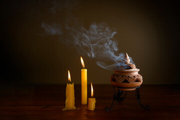 incense burning in an incense burner on the table with candles.Religion concept.