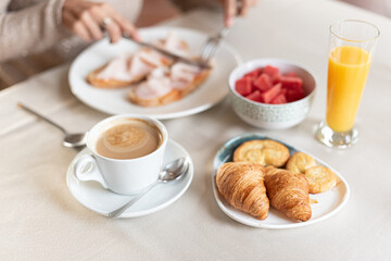 Coffee and croissant for breakfast served at a table.