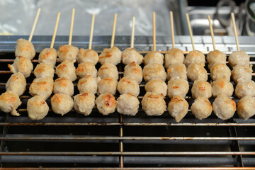 Pork Meatballs Skewers are grilled on a smokeless electric grill. (selective focus)