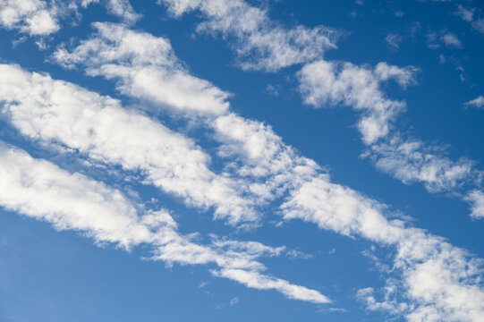 Dramatic cloudscape with fast moving white clouds against a blue sky, as a nature background
