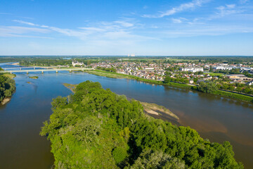 An island in the middle of the town of Sully sur Loire in Europe, in France, in the Center region, in the Loiret, in summer, on a sunny day.
