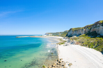 The verdant Norman Cliffs above the white pebble beach in Europe, France, Normandy, towards Deauville, in summer, on a sunny day.