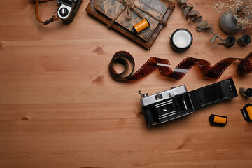 Top view vintage books, film rolls and retro camera on wooden table.