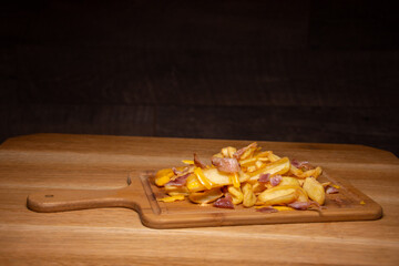 french fries with ham on a wooden plate
