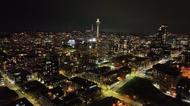 Cinematic 4K night illuminated aerial drone dolly shot of the Space Needle and Seattle Center, Pacific Science Center in Belltown and Queen Anne near Danny Triangle, Kiara in Seattle, Washington