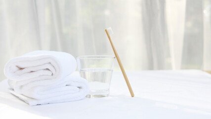 Toothbrush, toothpaste and towel and healthcare concept, glass of water, white a cotton towel and powder