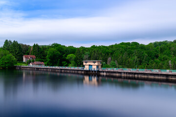 Obraz premium The Lac de Chaumecon dam surrounded by forest in Europe, France, Burgundy, Nievre, Morvan, in summer, on a sunny day.