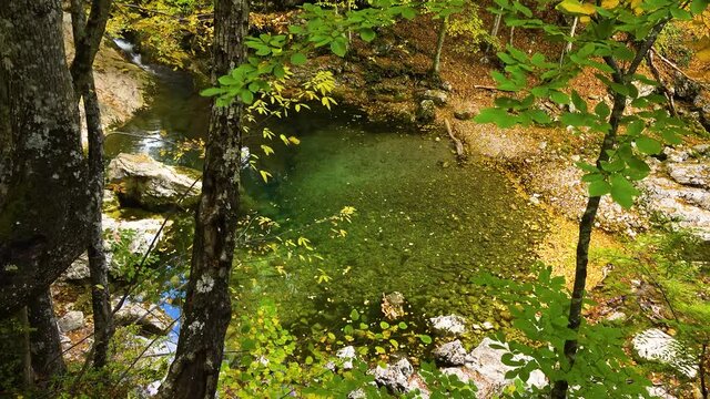 View of a beautiful waterfall and the cloud of tiny water drops under the sun rays and lens flares. Camera panningement. Gimbal shot