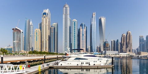 Dubai Marina and Harbour skyline architecture wealth luxury travel in United Arab Emirates with boat yacht panorama