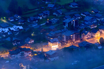 The close-up on the chalets of the town of Les Houches in the Mont Blanc massif in Europe, in France, in the Alps, towards Chamonix, in summer, at night.