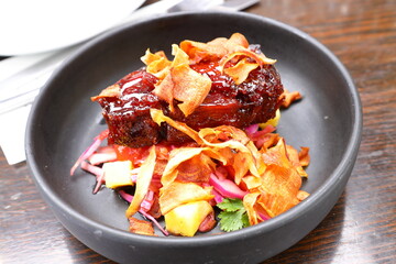 A meal of pork belly as prepared by a restaurant.