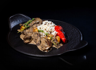Meat in sauce and rice on a platter..