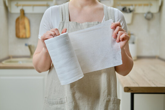 A Woman Holds A Roll Of Cloth Towels In Her Hands While Standing On A Home Kitchen, Close-up