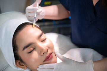 Obraz na płótnie Canvas young Asian woman making cosmetology treatment skin injection, Mesotherapy of face beauty care
