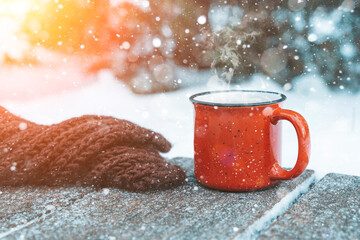 Mulled wine or tea on a wooden background during a snowfall in the forest. Winter hot drinks with...