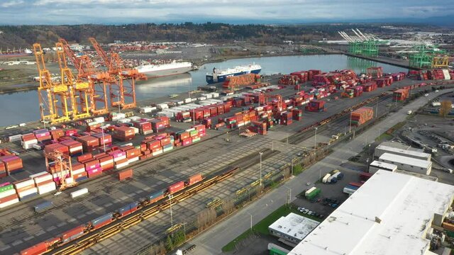 Cinematic 4K drone footage of shipping containers piled high, cranes, car transport ships on the West Coast at the Port of Tacoma, Pacific Northwest in Washington